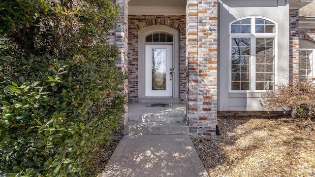 doorway to property featuring brick siding