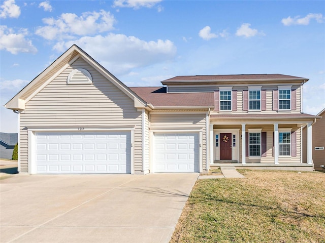 traditional-style house with a garage, driveway, a front lawn, and covered porch