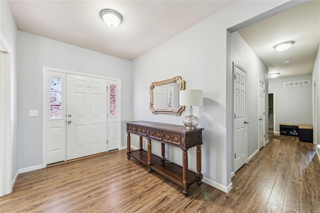 entrance foyer with visible vents, baseboards, and wood finished floors