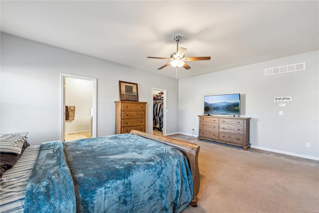 carpeted bedroom featuring visible vents, a spacious closet, baseboards, and ensuite bathroom