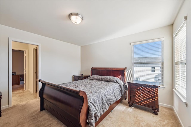 bedroom featuring light carpet and baseboards