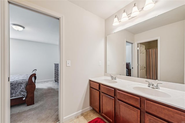 full bath featuring double vanity, a sink, and connected bathroom