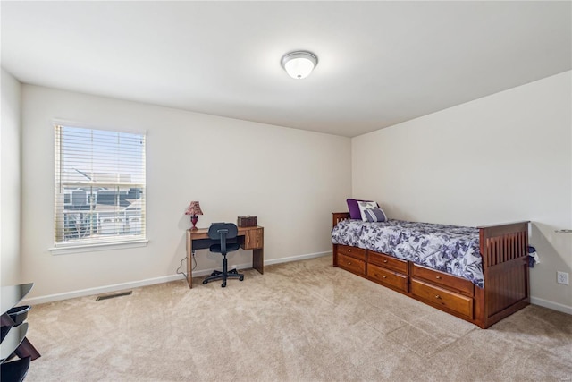 bedroom featuring baseboards, visible vents, and light colored carpet