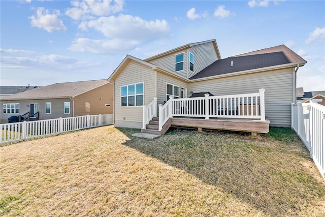 back of house featuring a fenced backyard, a deck, and a yard