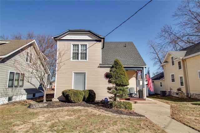 view of front of property featuring a shingled roof, a front yard, and central AC