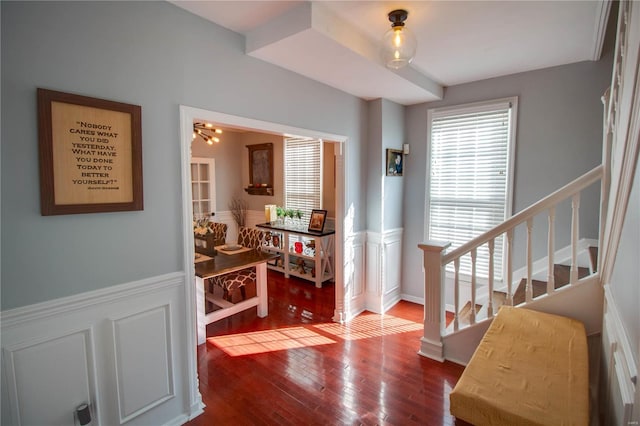 interior space featuring a wainscoted wall, wood finished floors, and stairs