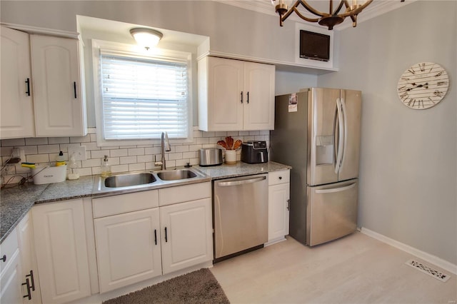 kitchen featuring tasteful backsplash, visible vents, stainless steel appliances, white cabinetry, and a sink