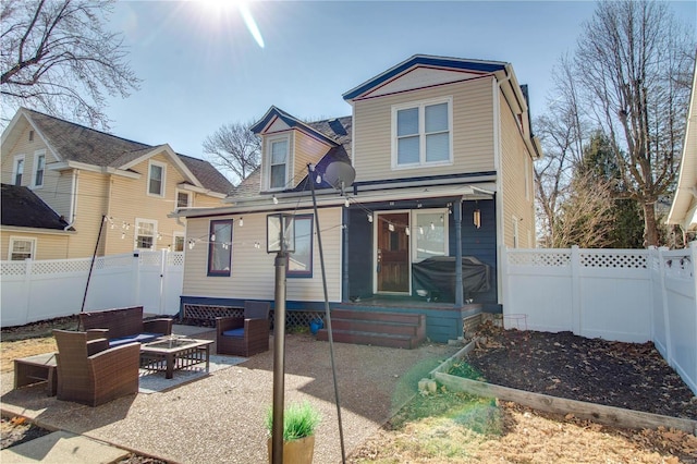 view of front of house with entry steps, a fenced backyard, an outdoor living space, and a patio