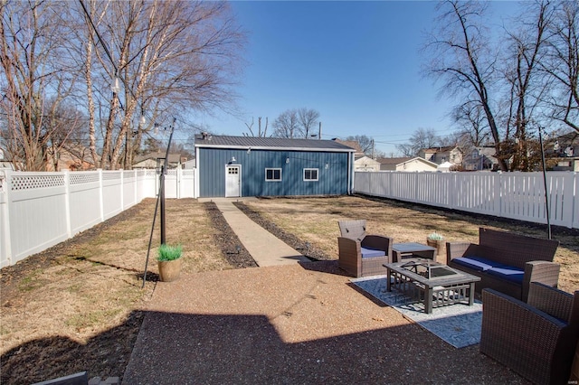 view of yard featuring an outbuilding, a fenced backyard, and an outdoor living space with a fire pit