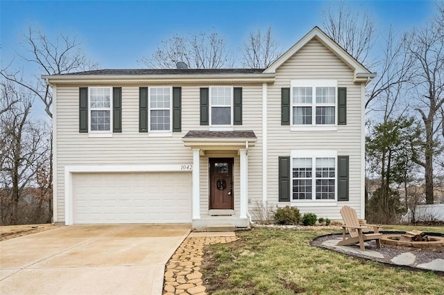 traditional-style house featuring a fire pit, driveway, and an attached garage