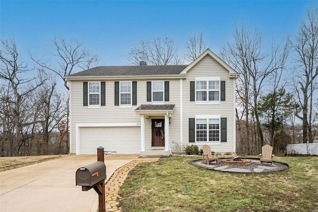 traditional-style house featuring a garage, an outdoor fire pit, a front lawn, and concrete driveway