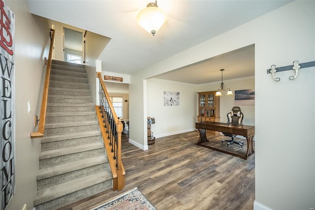 foyer featuring baseboards, crown molding, stairway, and dark wood-style flooring