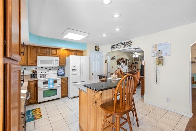 kitchen featuring arched walkways, decorative backsplash, brown cabinetry, light tile patterned flooring, and white appliances