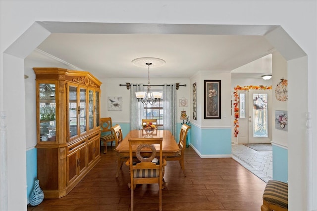 dining area with baseboards, dark wood-type flooring, and a notable chandelier