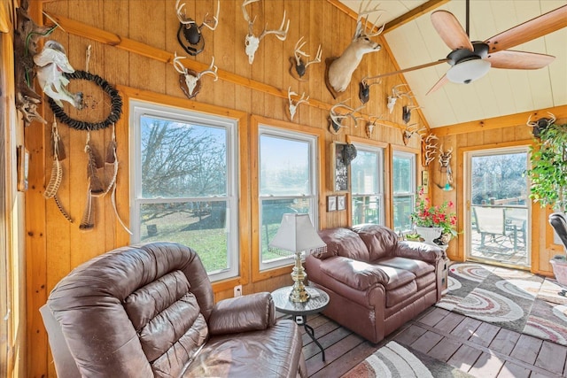 sunroom with lofted ceiling with beams, plenty of natural light, and a ceiling fan