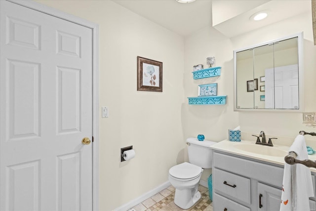 bathroom featuring baseboards, vanity, and toilet