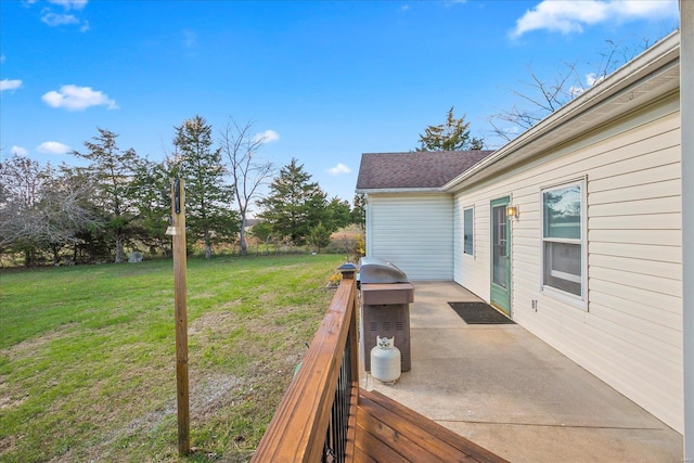 wooden deck featuring a patio and a lawn