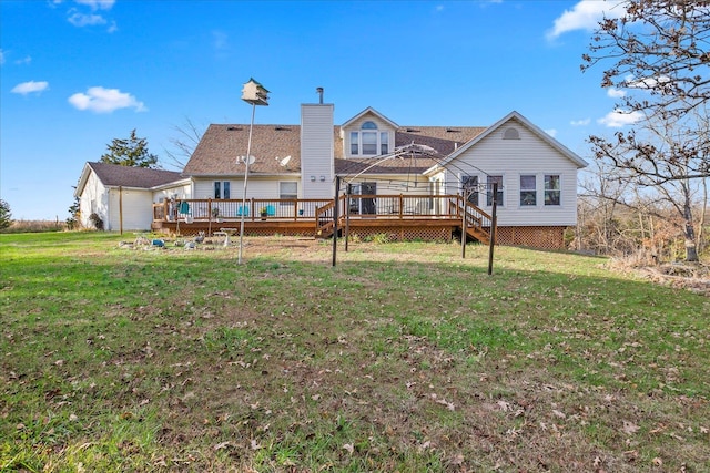 rear view of house featuring a chimney, a deck, and a yard