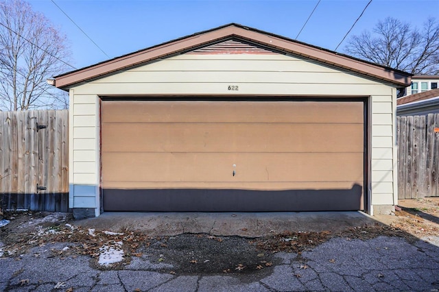 detached garage featuring fence