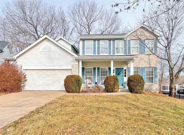 colonial inspired home with a porch, concrete driveway, an attached garage, and a front lawn