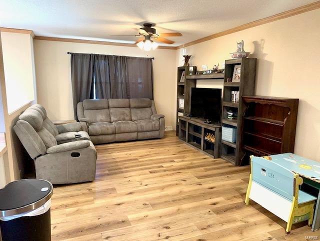 living room featuring crown molding, ceiling fan, and wood finished floors