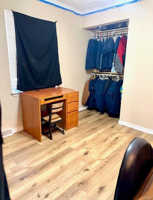 walk in closet with wood finished floors