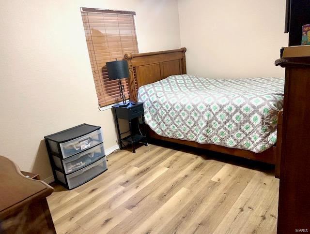 bedroom with baseboards and wood finished floors