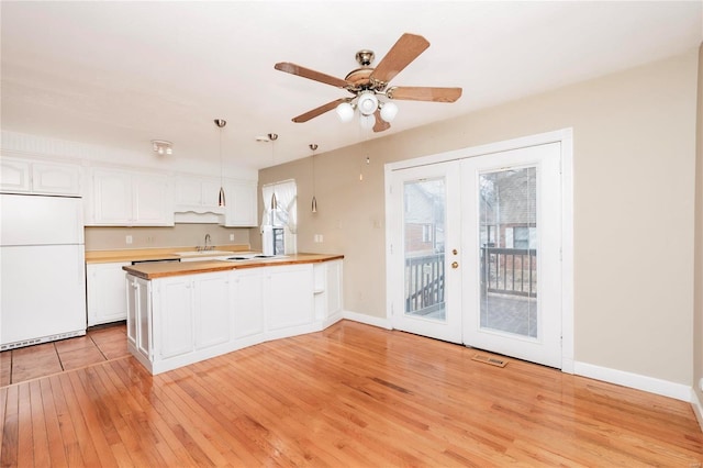 kitchen featuring french doors, light wood-style flooring, white cabinets, white appliances, and a peninsula