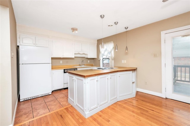 kitchen featuring light wood-style flooring, freestanding refrigerator, white cabinetry, a sink, and dishwashing machine