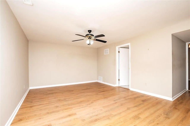 spare room with a ceiling fan, visible vents, light wood-style flooring, and baseboards