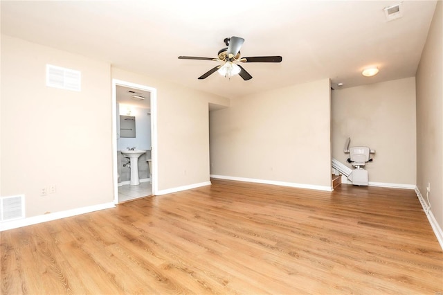 empty room with visible vents, light wood-style flooring, and baseboards