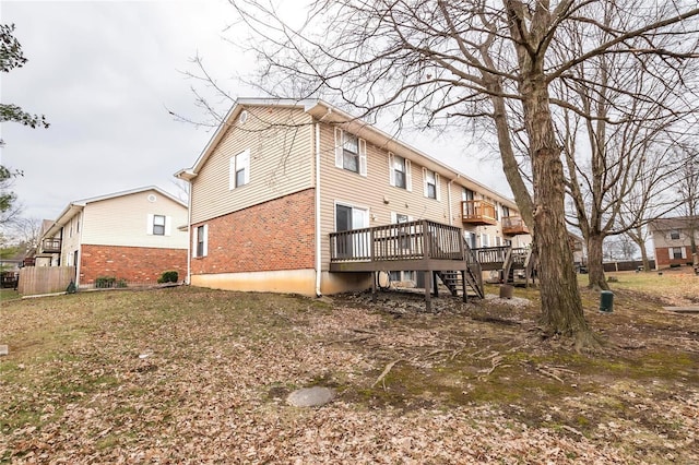 rear view of property with stairway, a deck, and brick siding