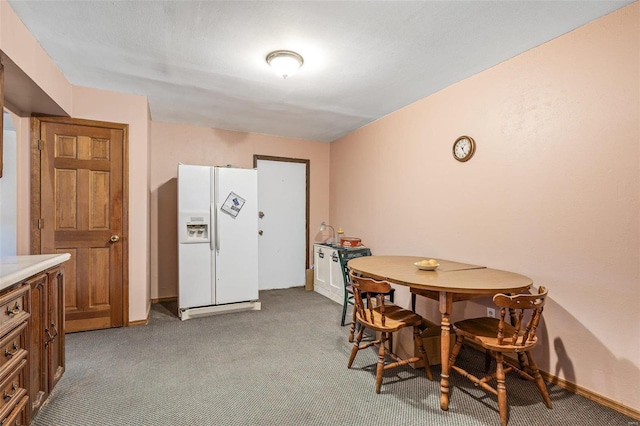 carpeted dining space featuring baseboards