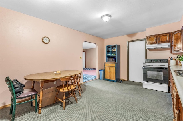 dining room featuring arched walkways and light carpet