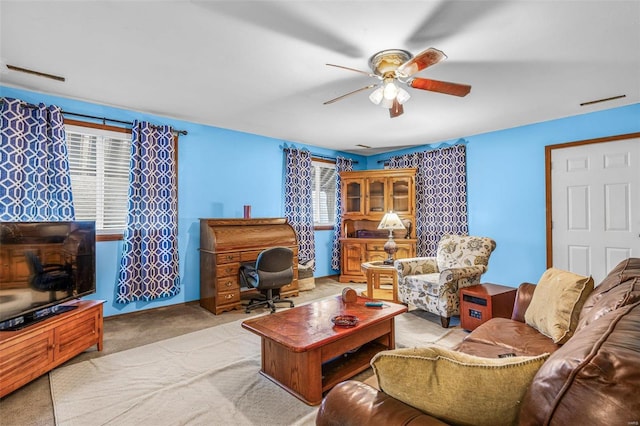 living area with carpet floors, plenty of natural light, and ceiling fan