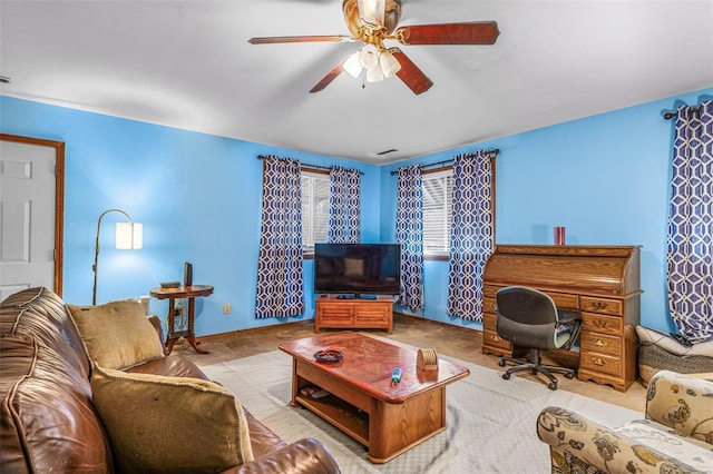 carpeted living area with a ceiling fan