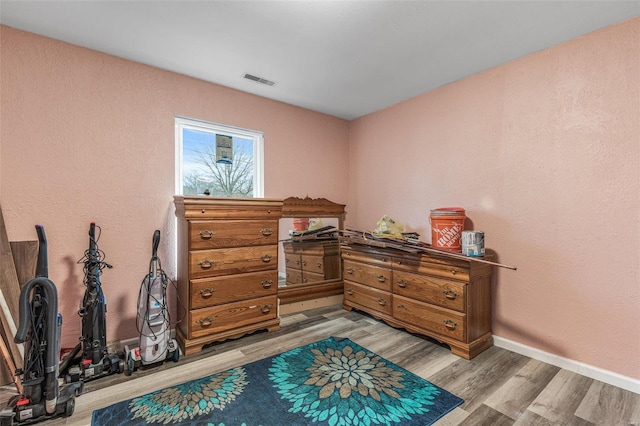 bedroom with baseboards, visible vents, and light wood-style floors