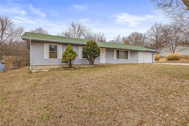 ranch-style home featuring an attached garage, driveway, fence, and a front lawn