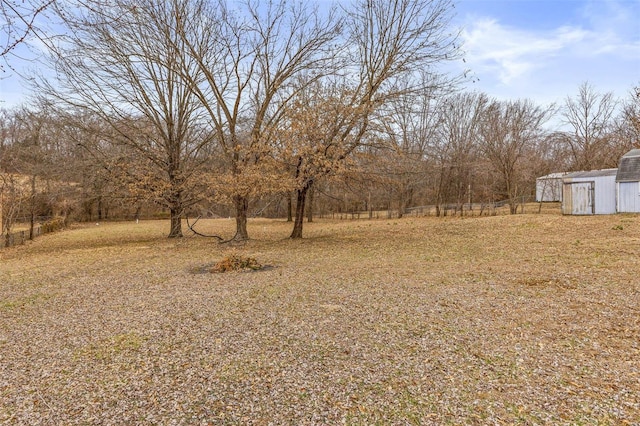 view of yard featuring an outbuilding and fence