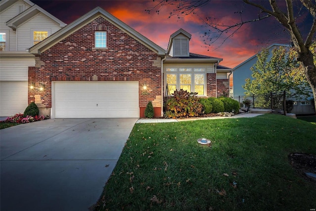 view of front of property featuring driveway, brick siding, a front lawn, and fence