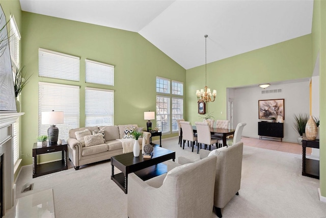 living area featuring light carpet, visible vents, a premium fireplace, high vaulted ceiling, and a notable chandelier