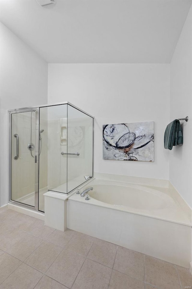 bathroom with a stall shower, a bath, and tile patterned floors