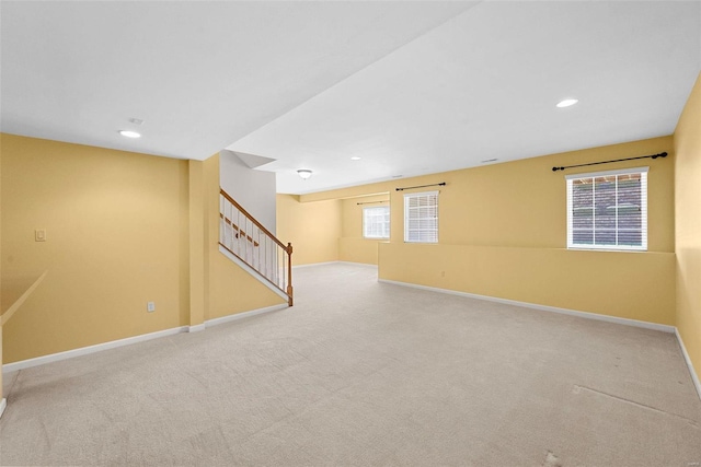 basement with a healthy amount of sunlight, baseboards, stairway, and carpet flooring