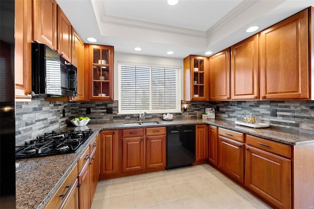 kitchen with black appliances, ornamental molding, brown cabinetry, and a sink