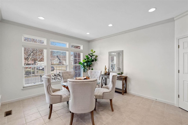 dining room featuring baseboards, visible vents, and crown molding