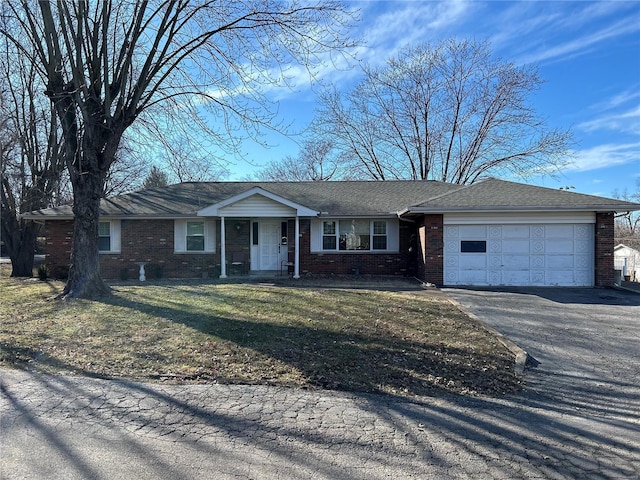 ranch-style home with driveway, a front yard, a garage, and brick siding