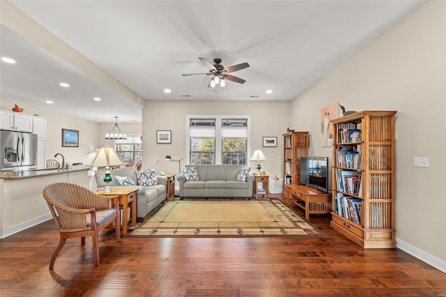 living room with recessed lighting, baseboards, wood finished floors, and ceiling fan with notable chandelier