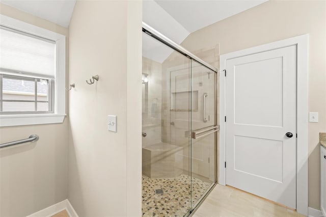 bathroom featuring baseboards and a shower stall