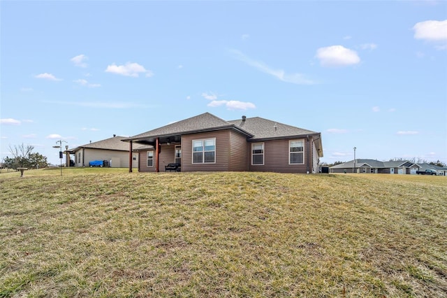 rear view of property featuring a yard