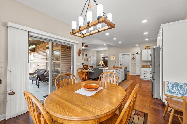 dining space with ceiling fan with notable chandelier, recessed lighting, and dark wood-style floors